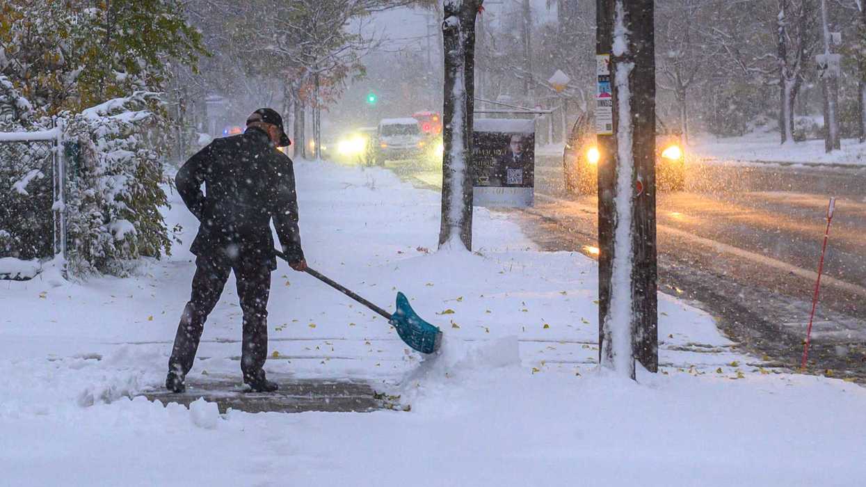 Someone shovels the sidewalk after a snowstorm in Toronto.