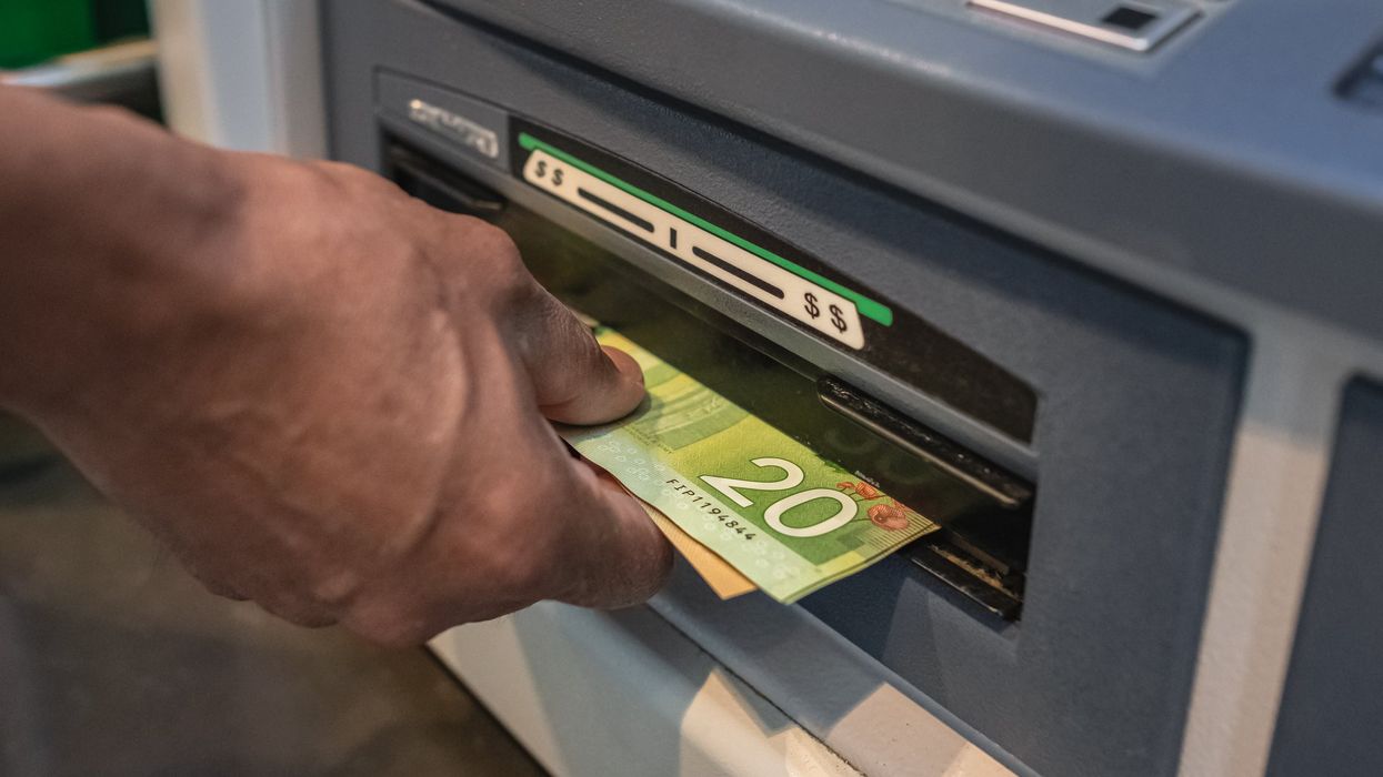 Someone withdrawing Canadian cash at an ATM.