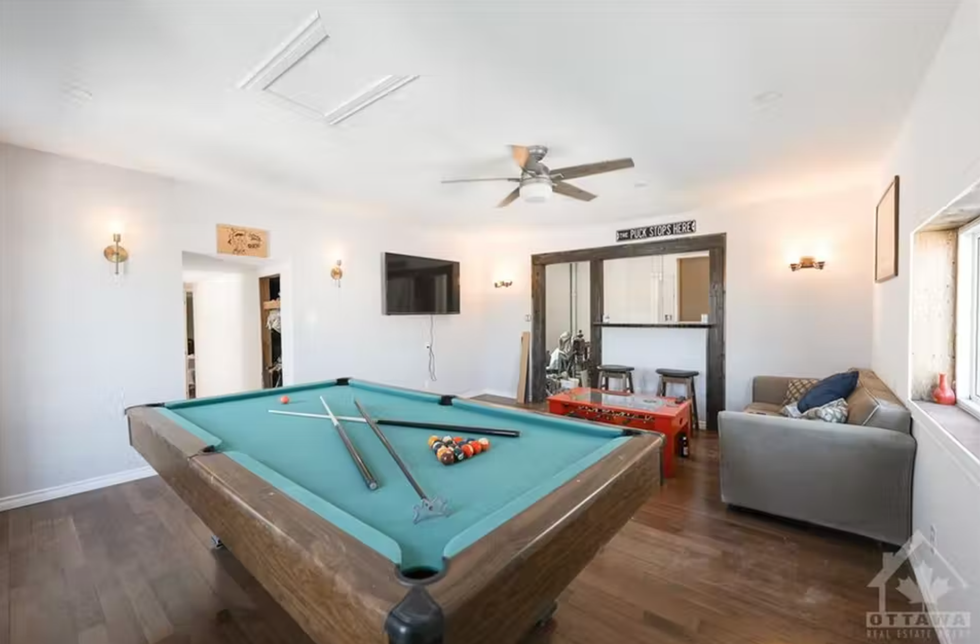 Spacious room with a pool table and a living room area.