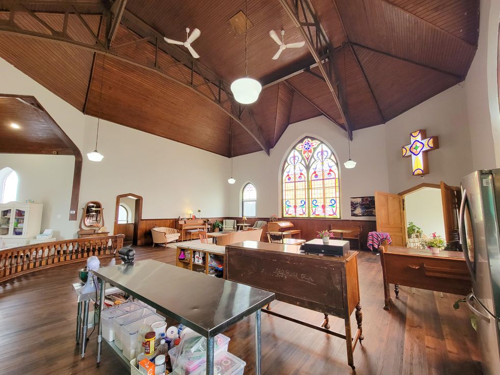 Spacous living room area of transformed church featuring stained glass windows.
