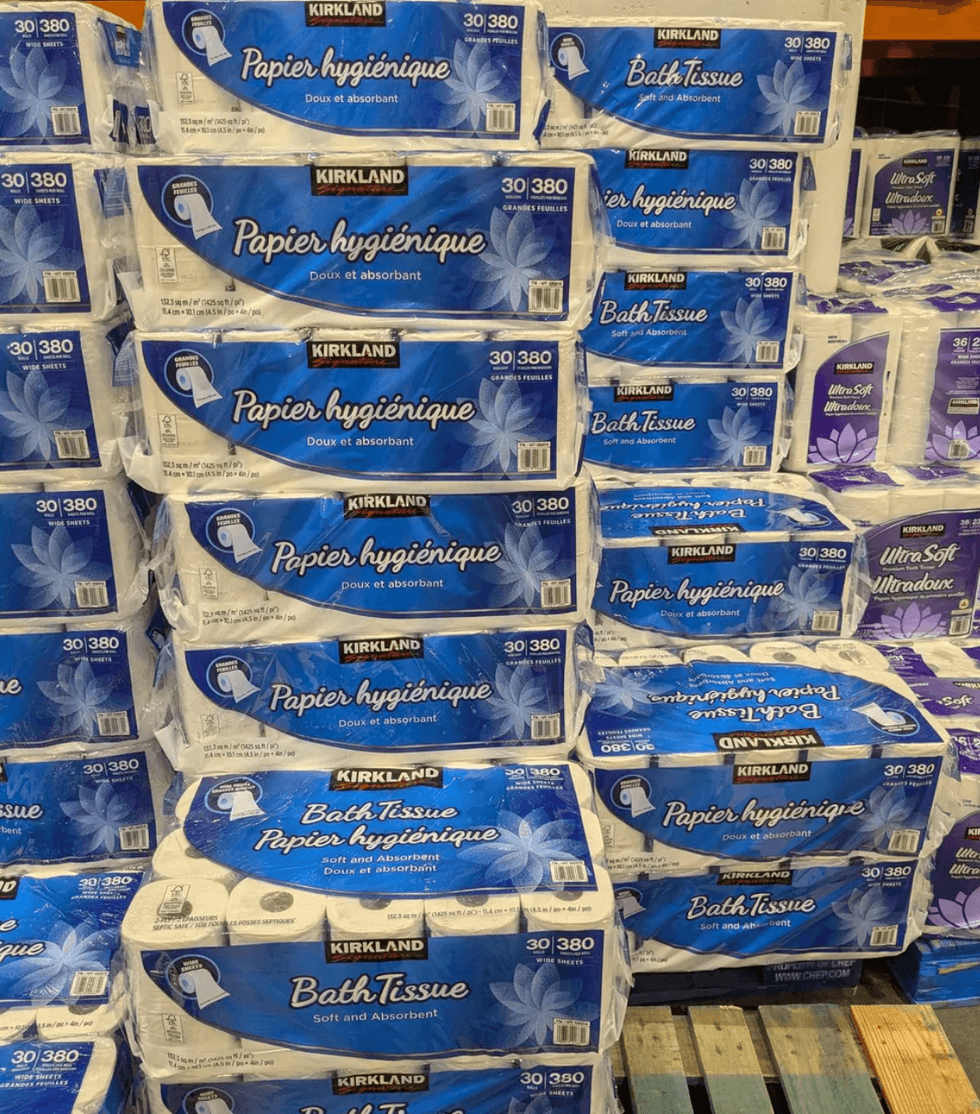 Stacks of Kirkland bath tissue packs on a pallet in a store.