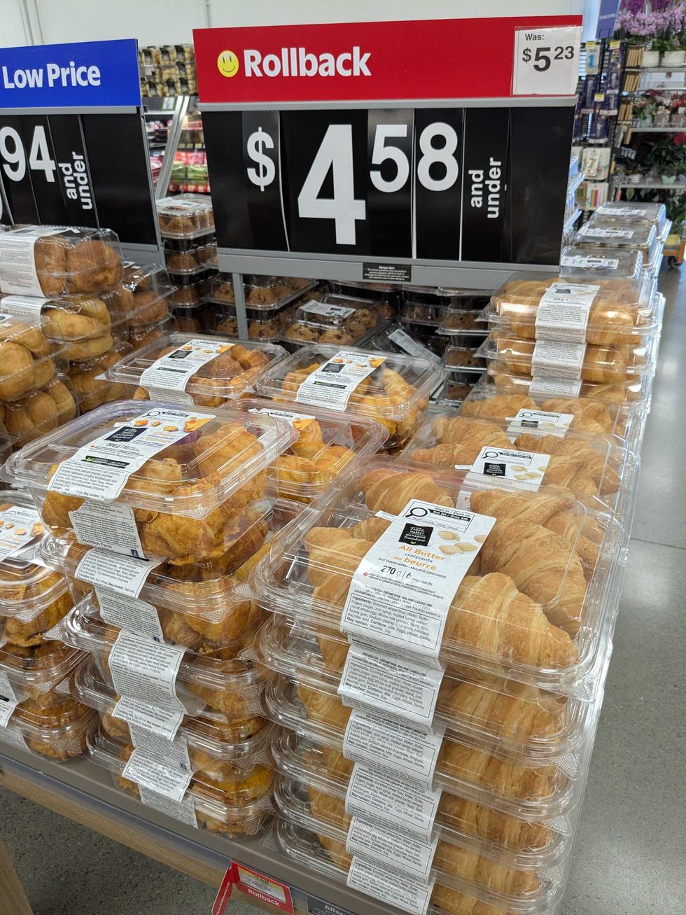 Stacks of packages of croissants at Walmart with a sign that says the price