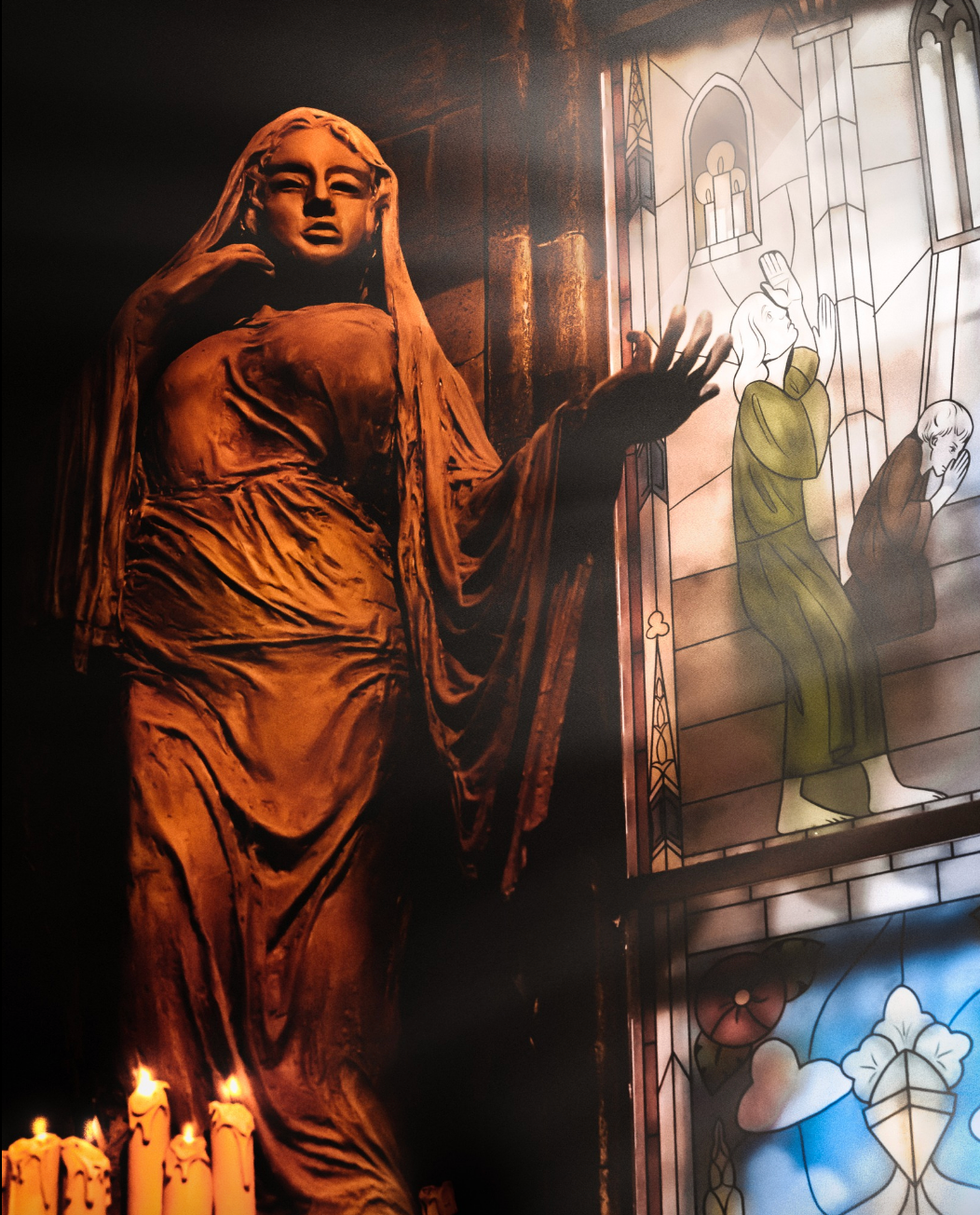 Statue de femme devant un vitrail dans une cath\u00e9drale.