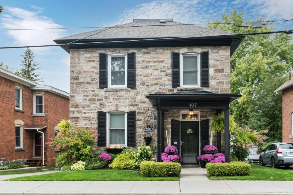 Stone home with purple flowers in Perth, Ontario.