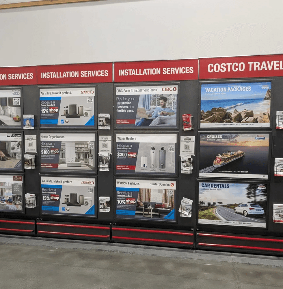 Store display showcasing installation services and travel deals at Costco.