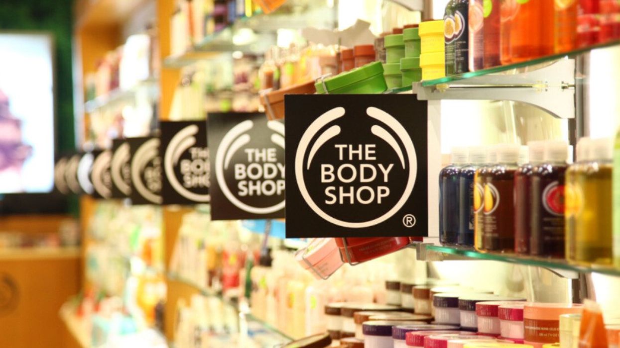 Store shelves filled with creams and shower gels with signs that read The Body Shop.
