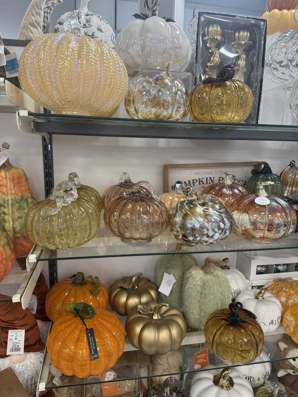 Store shelves filled with glass pumpkins in various colours.