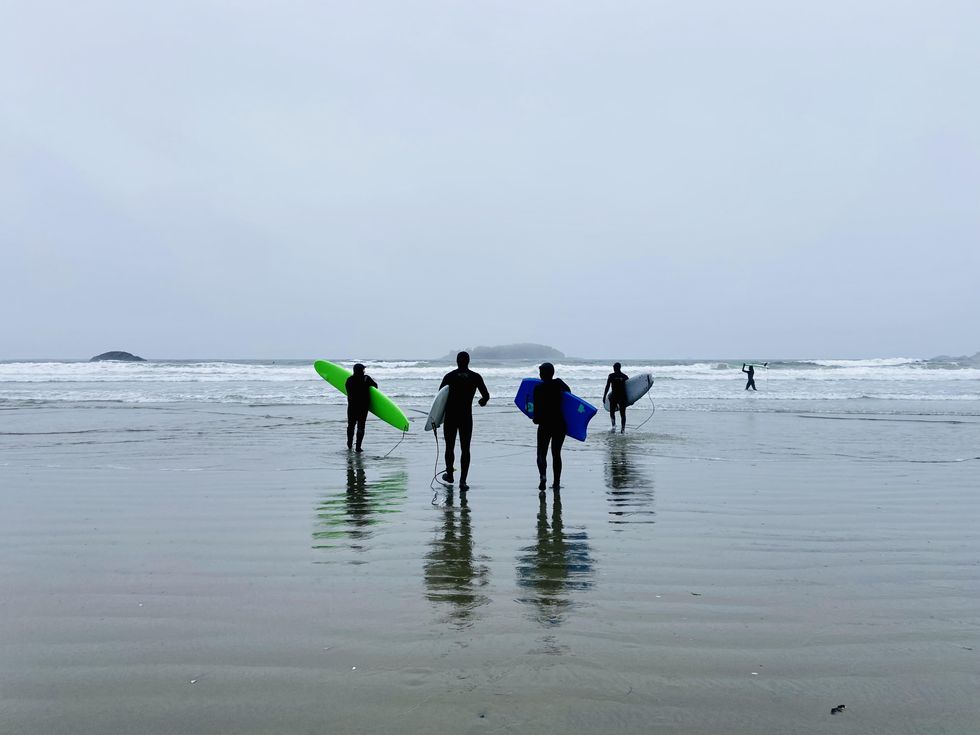 Surfers walking to the ocean on Chesterman Beach.