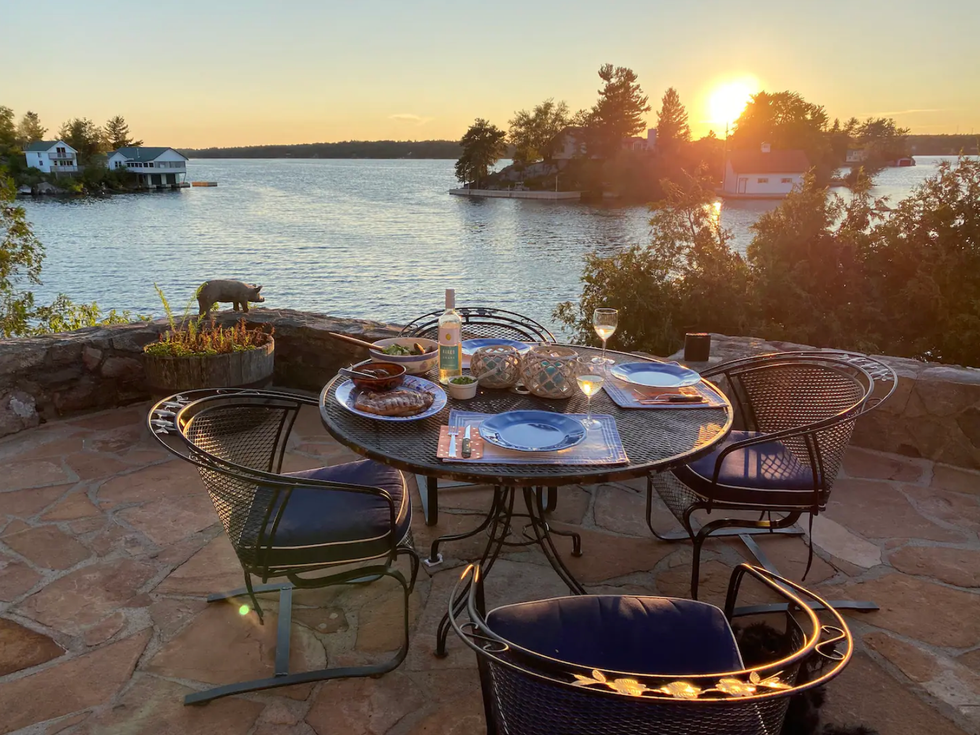Table and chairs on a patio overlooking the water.
