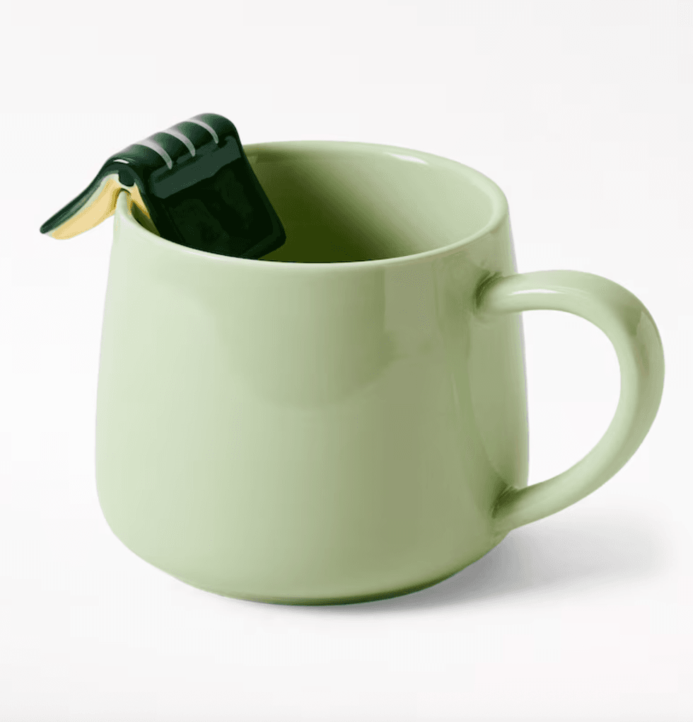 Tasse verte avec livre sur le c\u00f4t\u00e9 affich\u00e9 sur le site de Indigo.