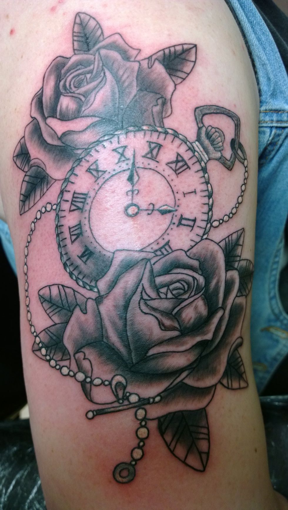 Tatouage d'une horloge de poche et de roses.