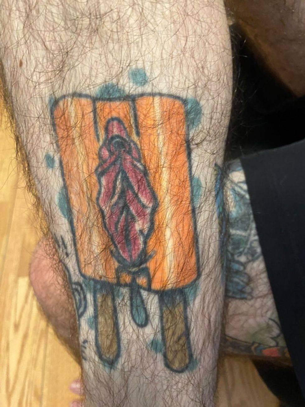 Tattoo d'un pop cycle en couleurs sur la jambe.