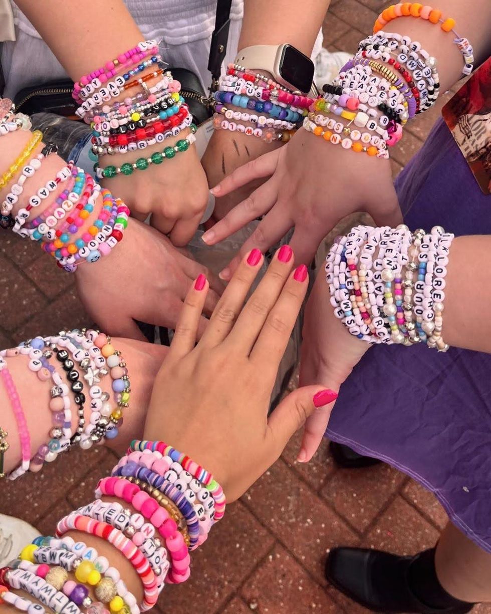 Taylor Swift fans showing off their friendship bracelets. 