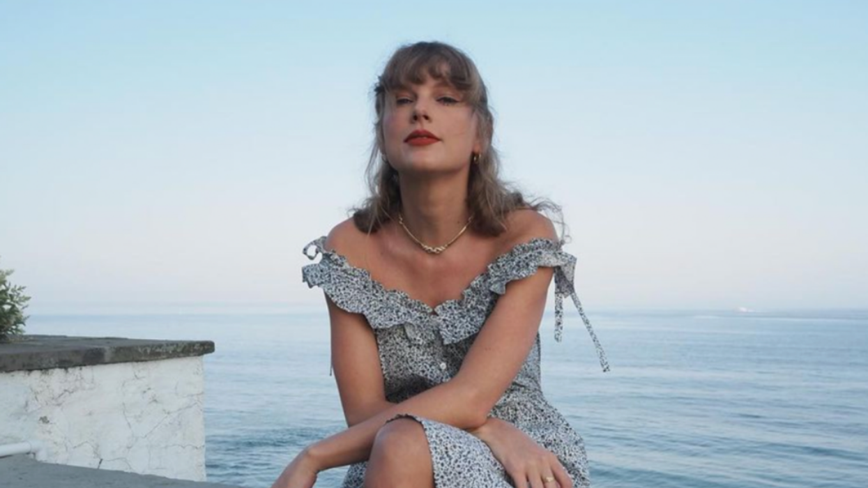 Taylor Swift sitting in a dress.
