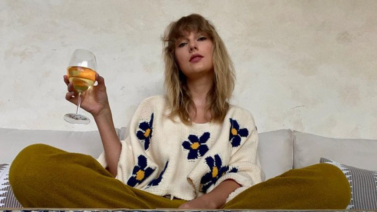 Taylor Swift with a glass of wine.