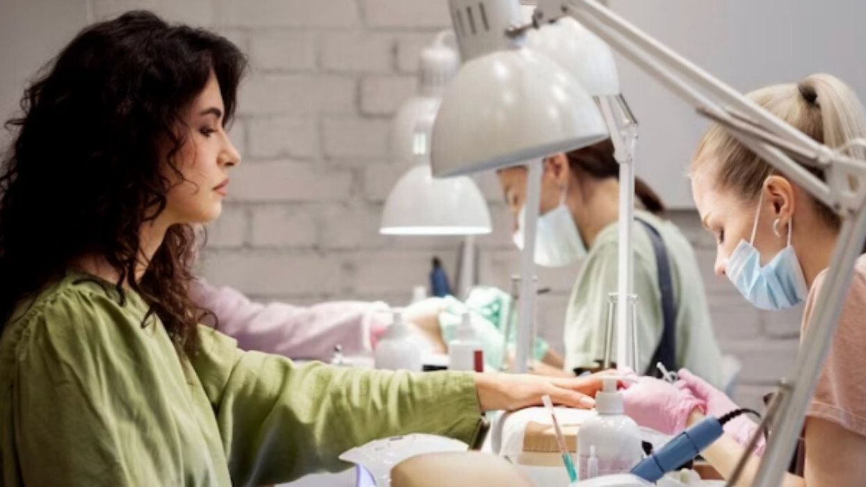 Technicienne en pose d'ongles et sa cliente.
