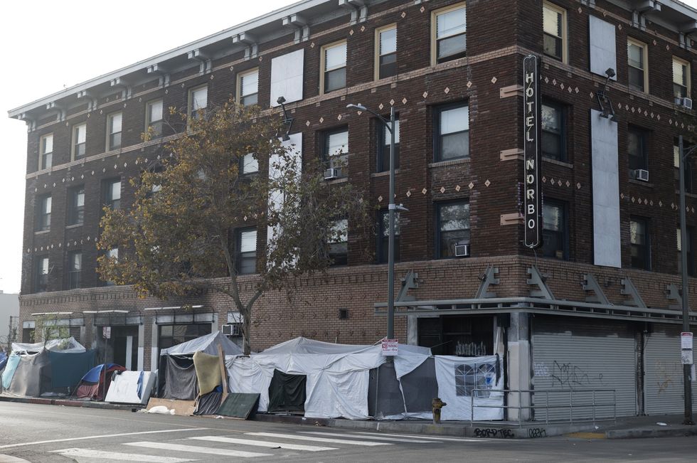Tents line the sidewalk in front of a hotel in Skid Row.