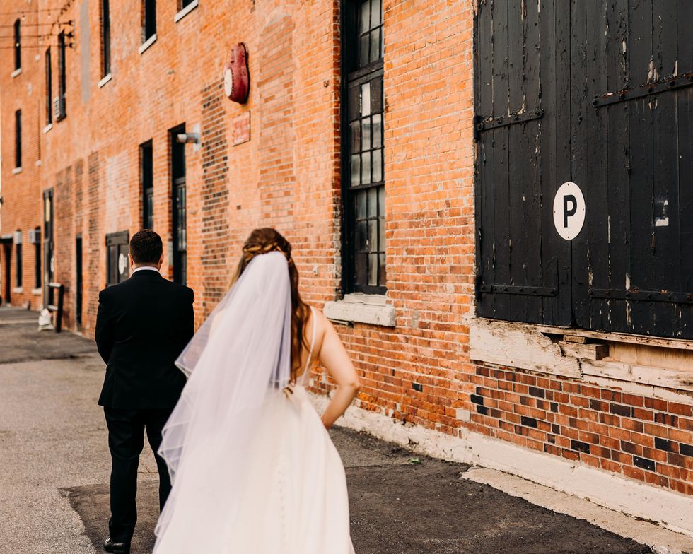 The back of a bride and groom before their first look on Chaudi\u00e8re Island.
