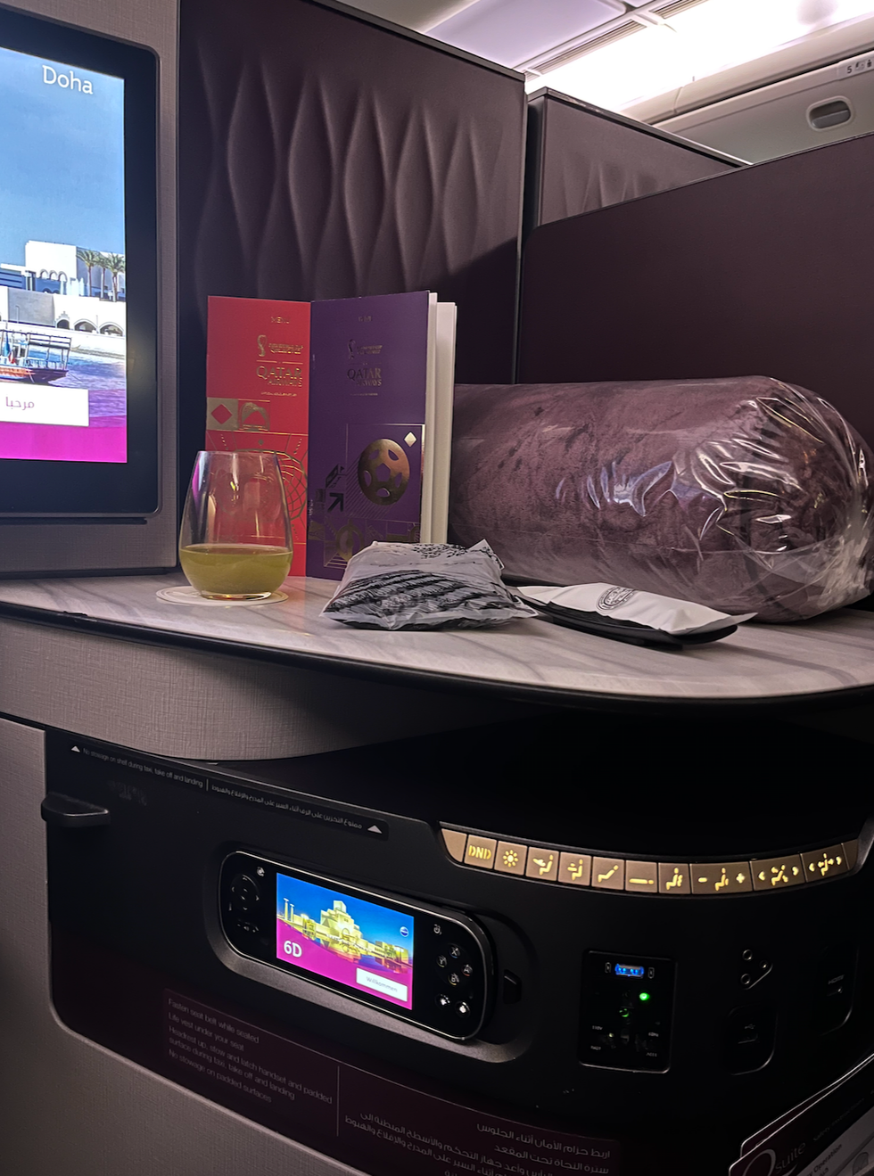 The blanket, hot towel, menues and lemon mint beverage served to me on Qatar Airways business class.
