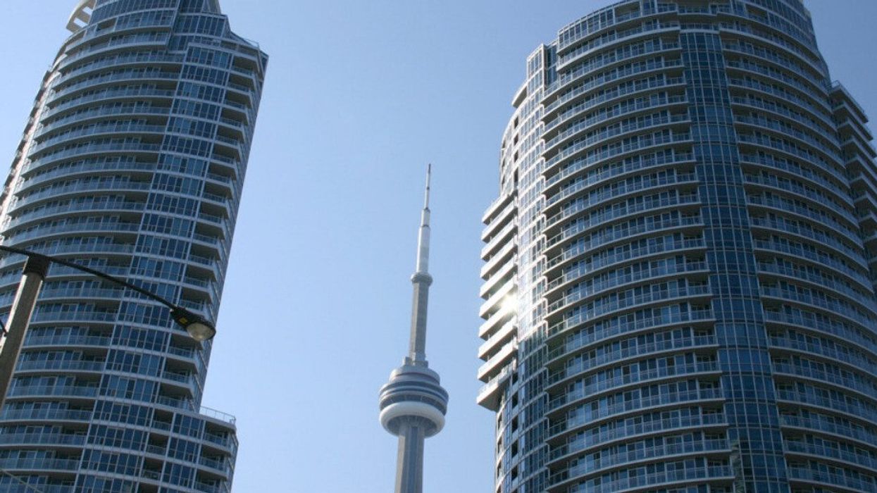 The CN Tower between two condo buildings.
