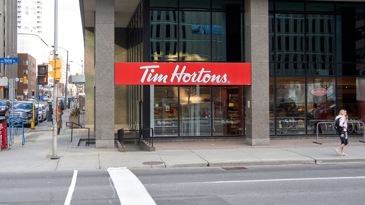 The exterior of a Tim Hortons on the corner of a street.