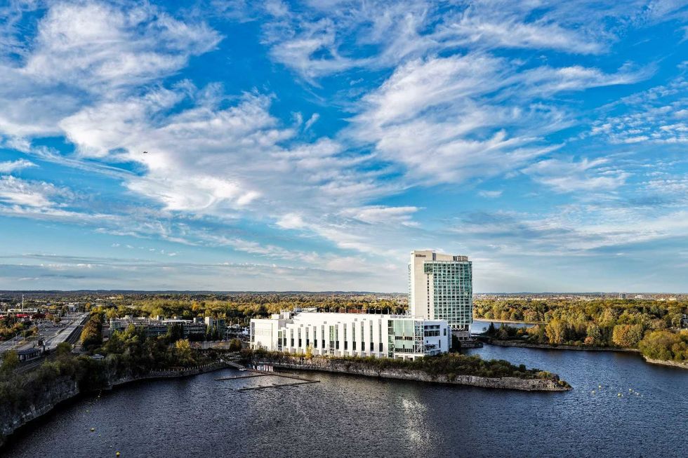 The exterior of Hu00f4tel-Casino du Lac-Leamy surrounded by trees and lakes.