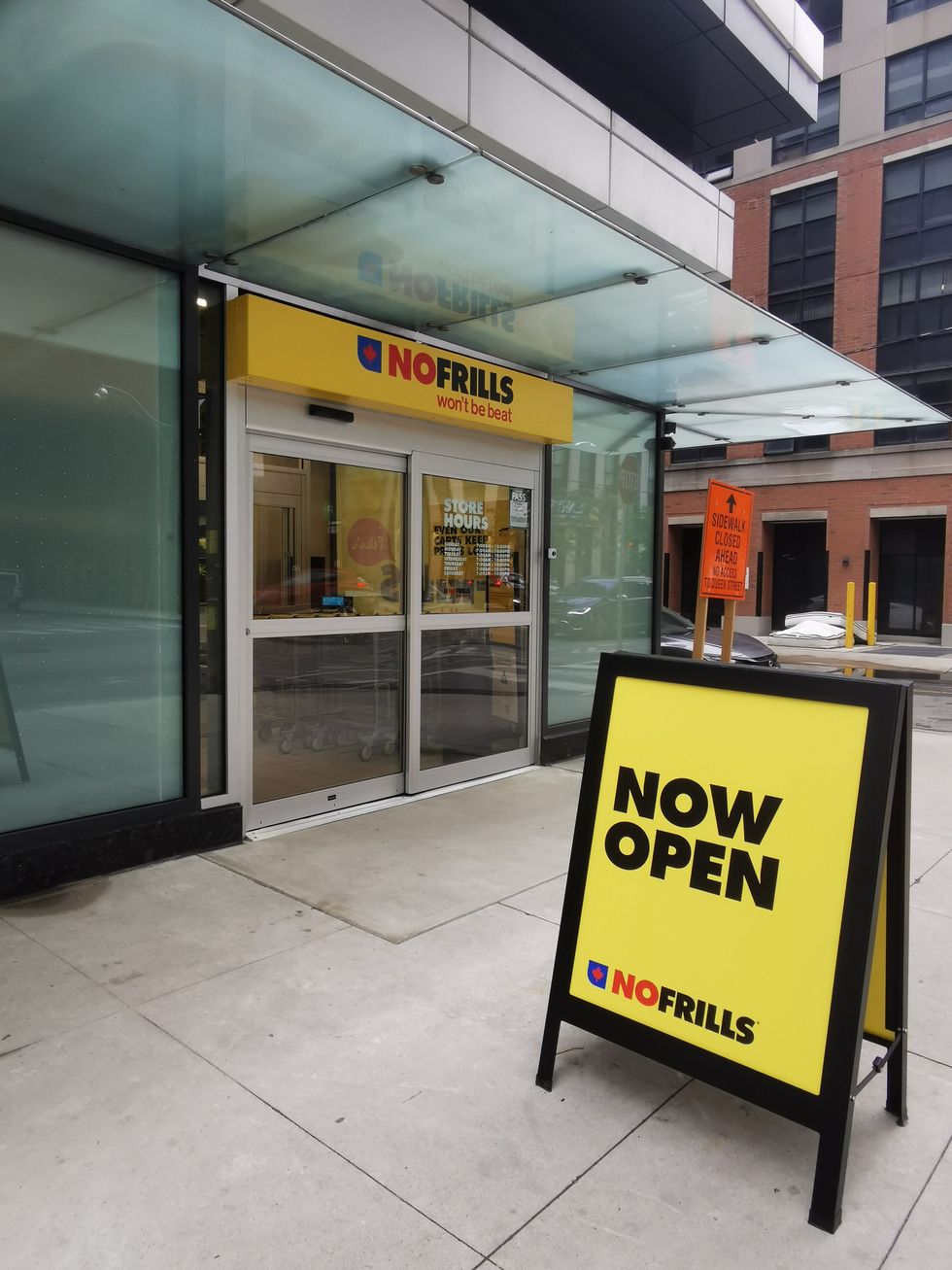 The front of No Frills store with a now open sign outside.