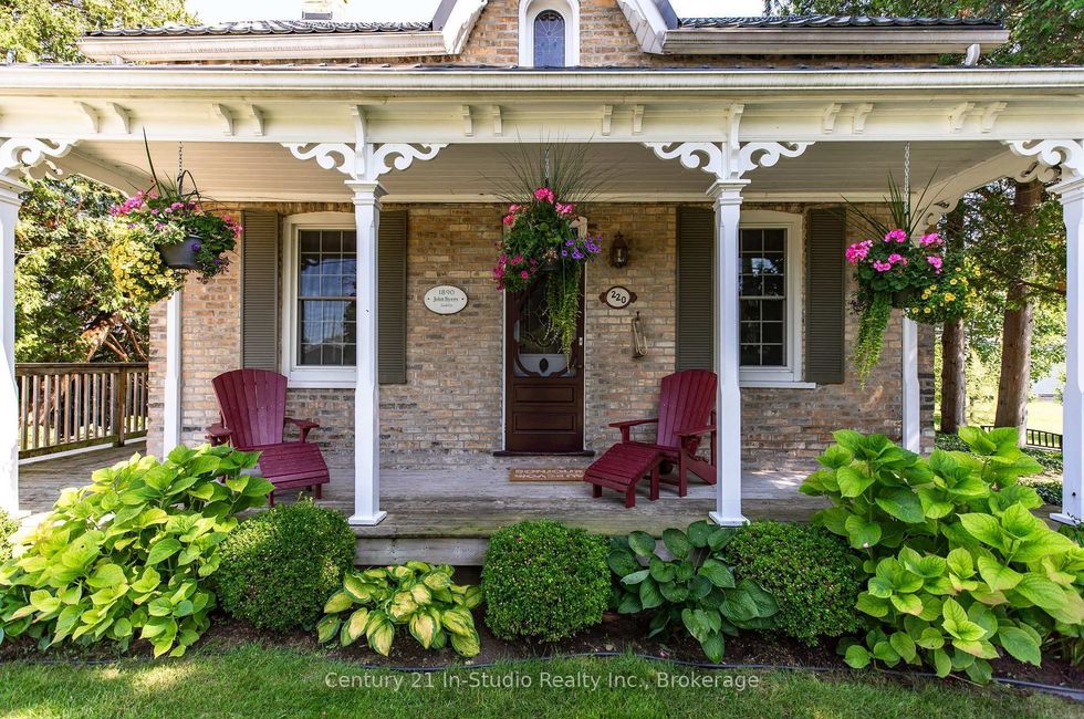 The front of the house with gardens and a porch.