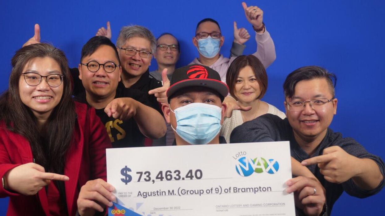 The group of Lotto Max winners collecting their cheque.