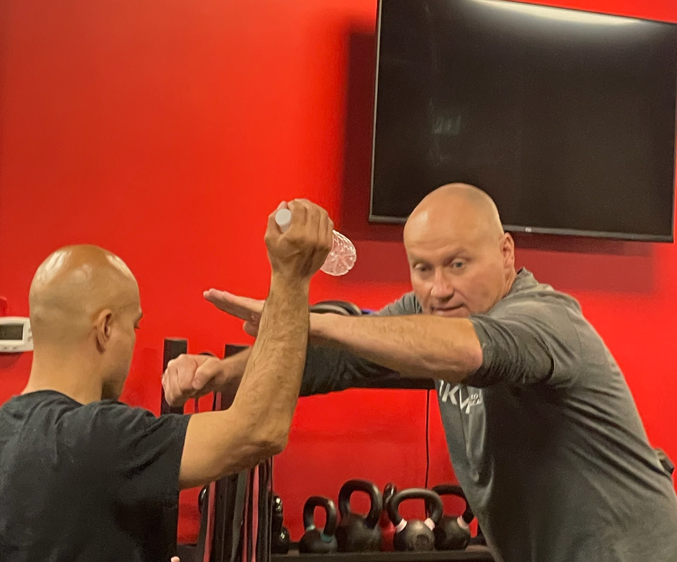 The instructors using a water bottle to act as a knife.