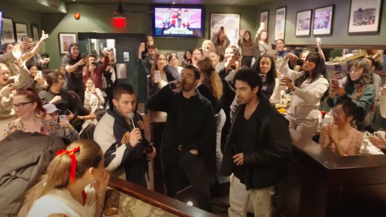 The Jonas brothers in a bar full of people.