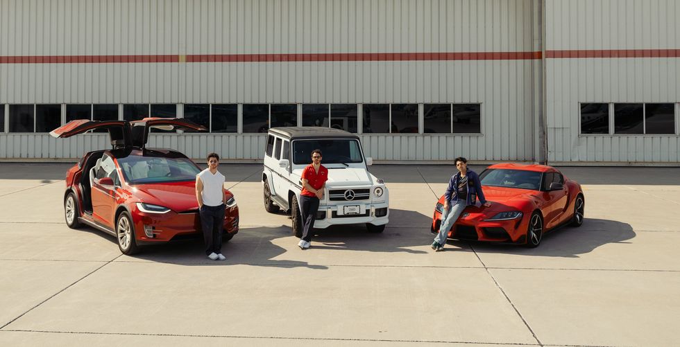 The Jonas Brothers standing with the cars they have listed on Turo.