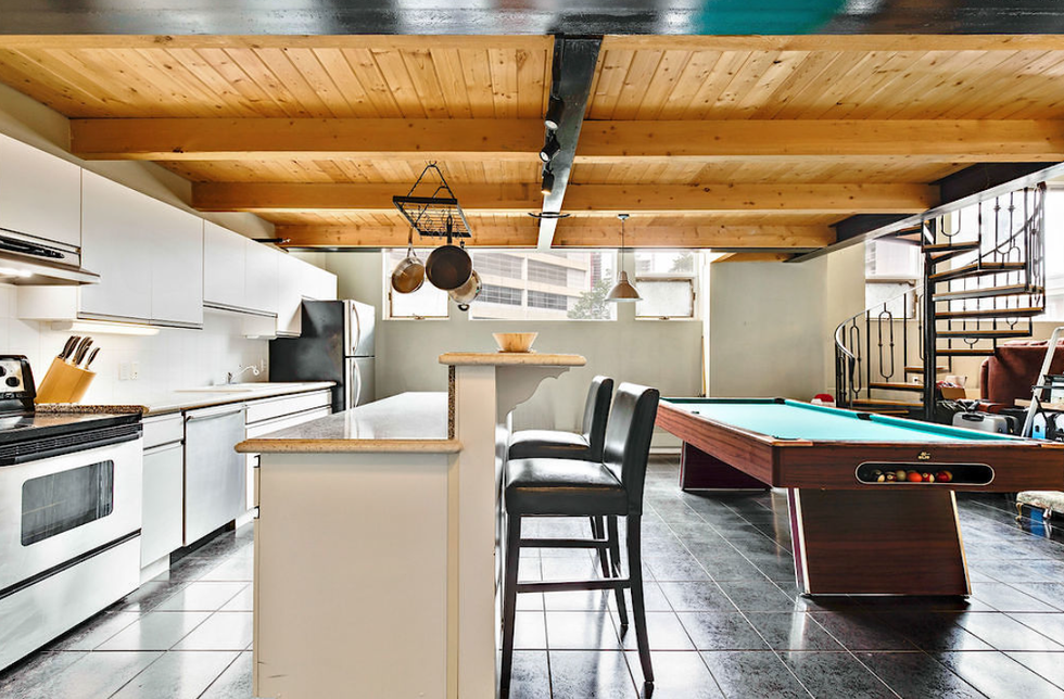 The kitchen features an island and wooden beams on the ceiling.