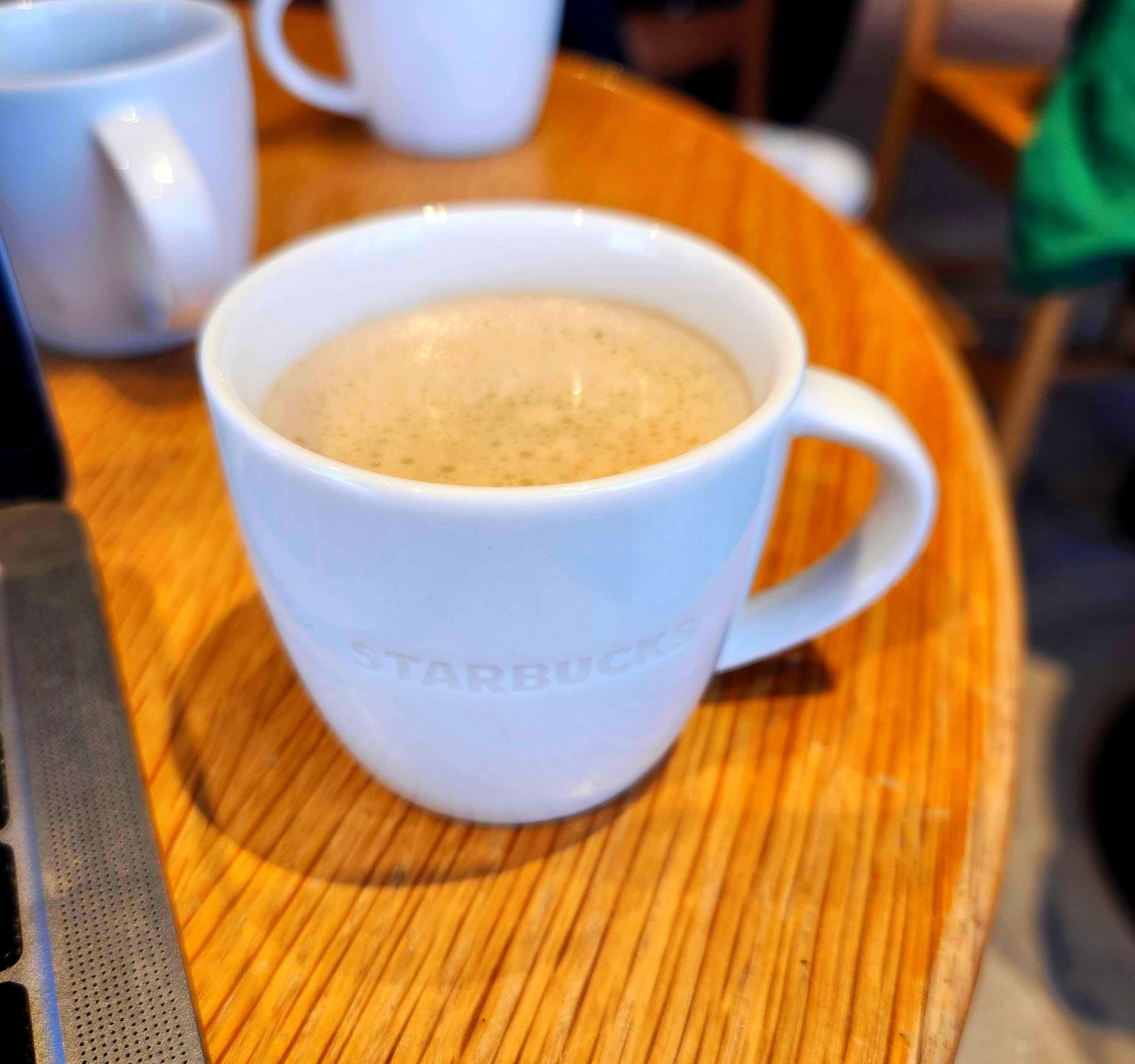 The Lavender Oat Latte at Starbucks in a white mug.