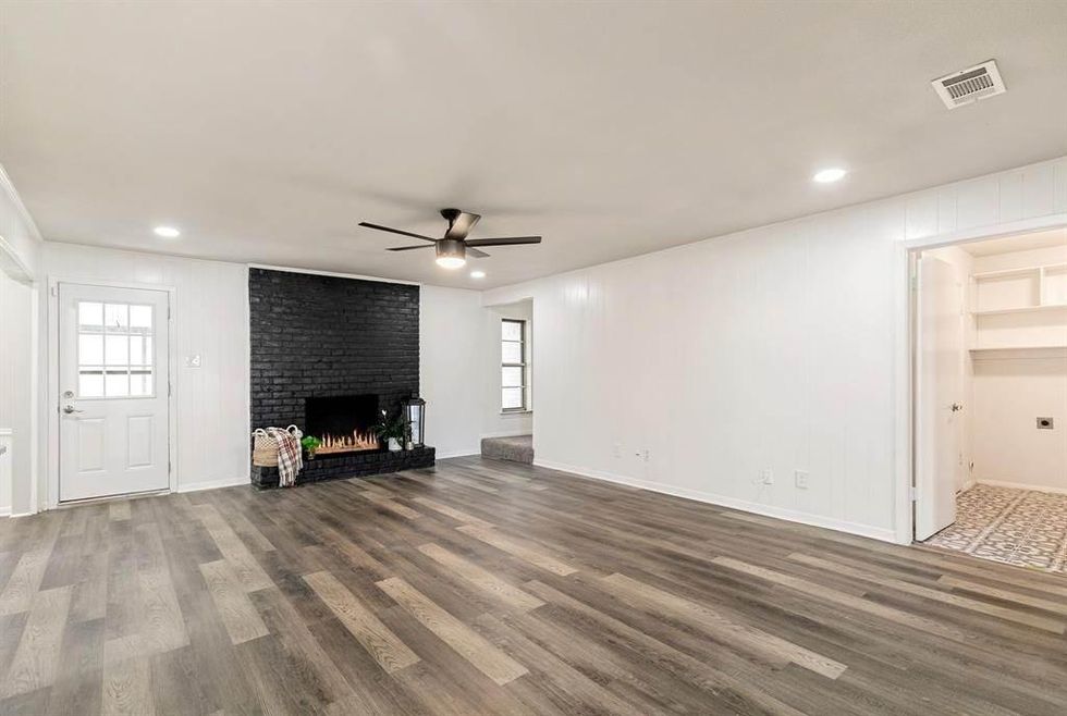 The living room with a black brick fireplace.