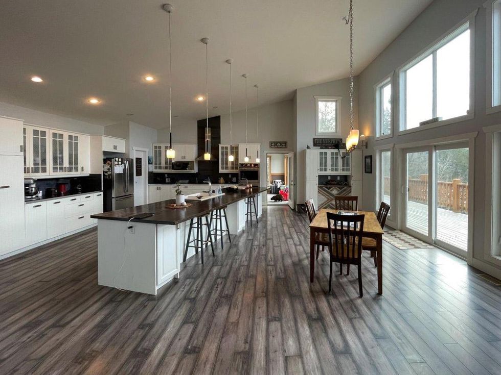 The luxurious kitchen with an island and dining table in the house for sale.