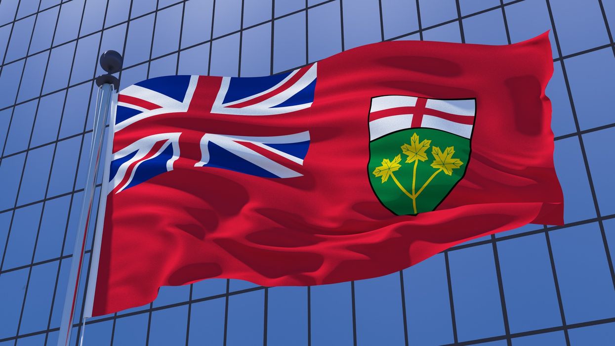 The Ontario flag in front of a glassy building (illustrative).