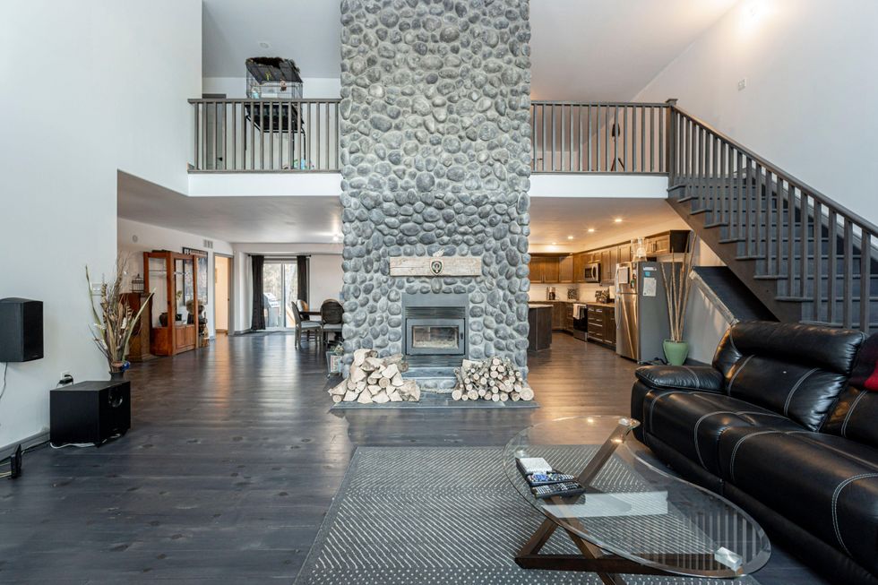 The open-concept kitchen and living area with large fireplace.