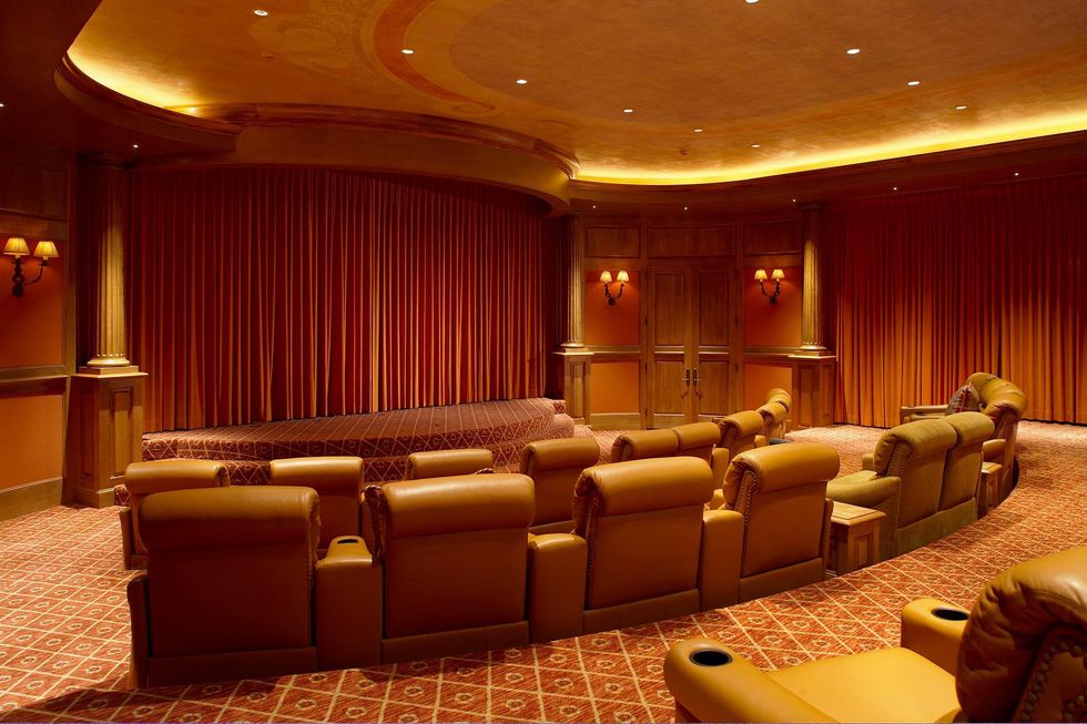 The orange seats and the draped stage in the luxurious home theatre.