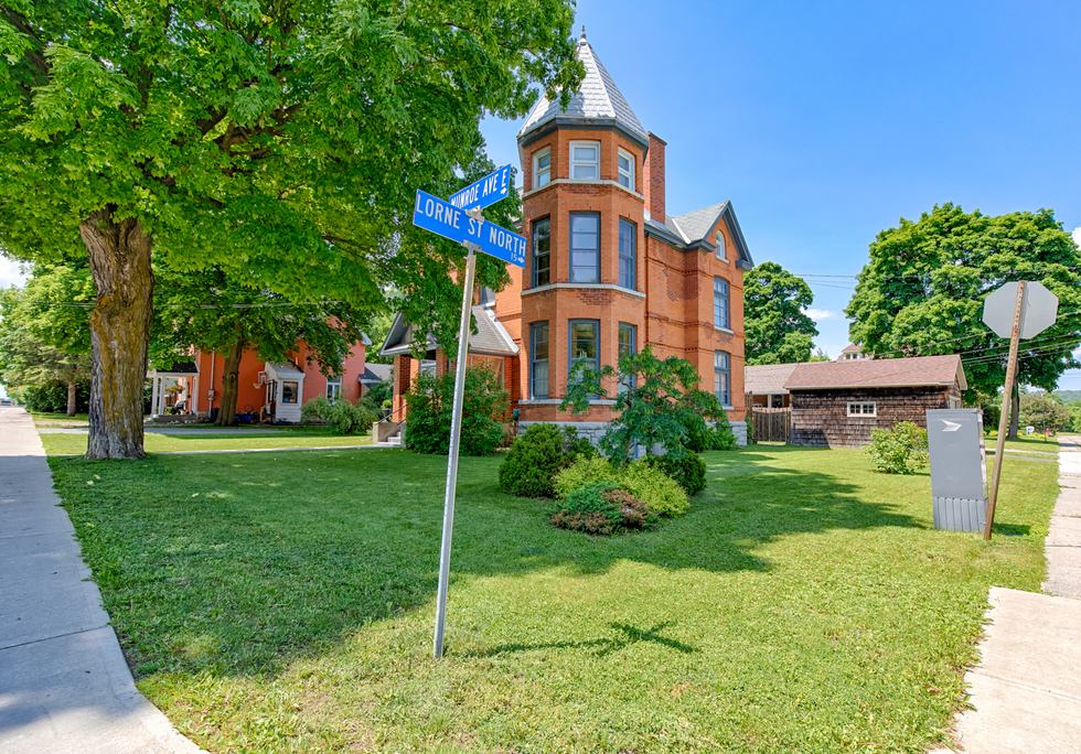 The outside of a red-bricked mansion, surrounded by greenery in Renfrew.