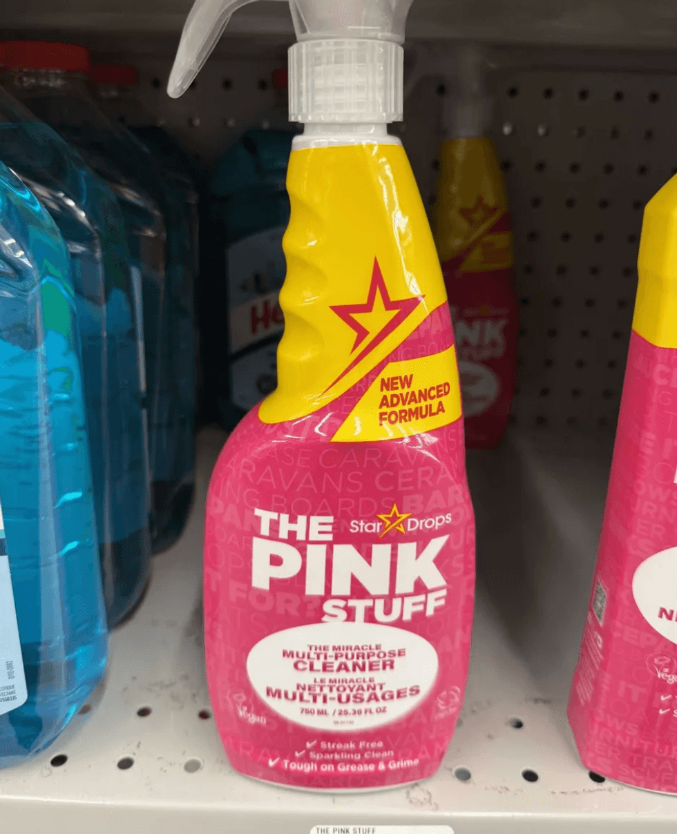 The Pink Stuff spray bottle on a store shelf, labeled "New Advanced Formula."