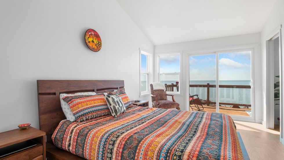 The primary bedroom with a view of the lake and a balcony.