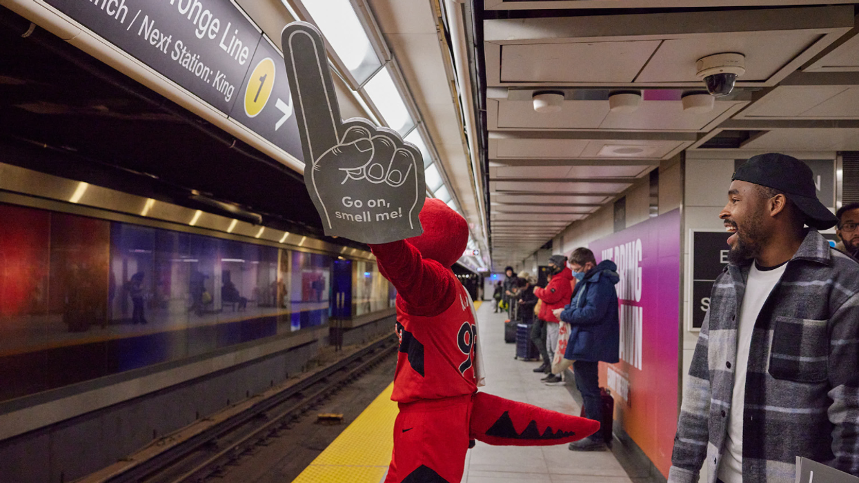 The Raptor waves a foam finger on a TTC platform in Toronto.