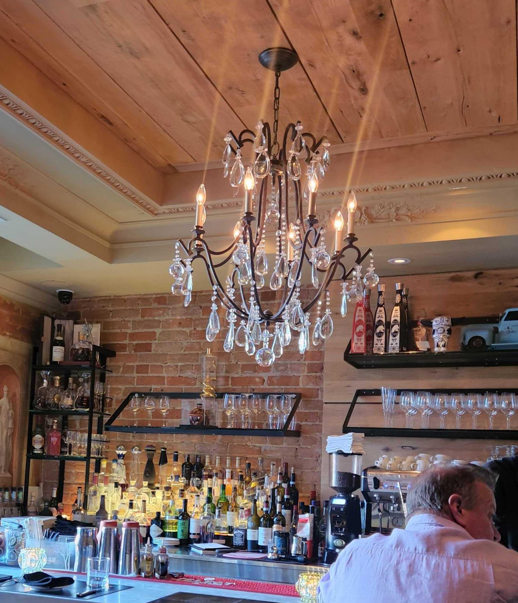 The restaurant bar under a chandelier.