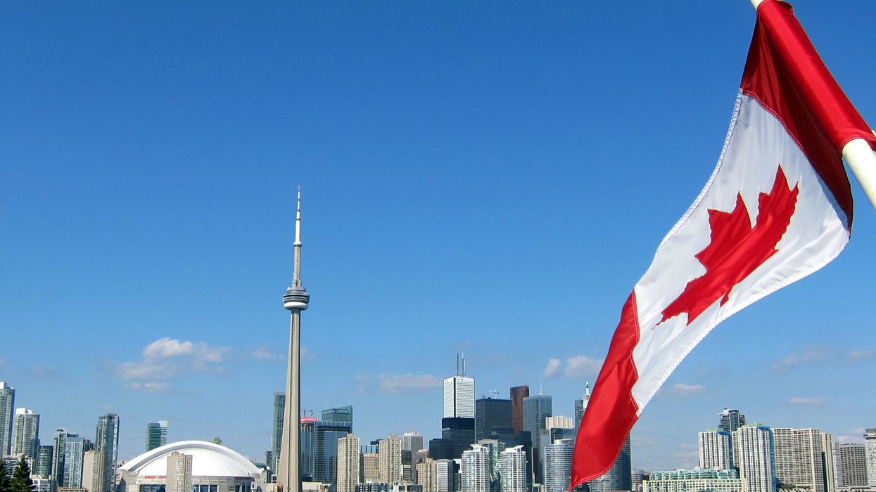 The Toronto skyline with a Canadian flag.