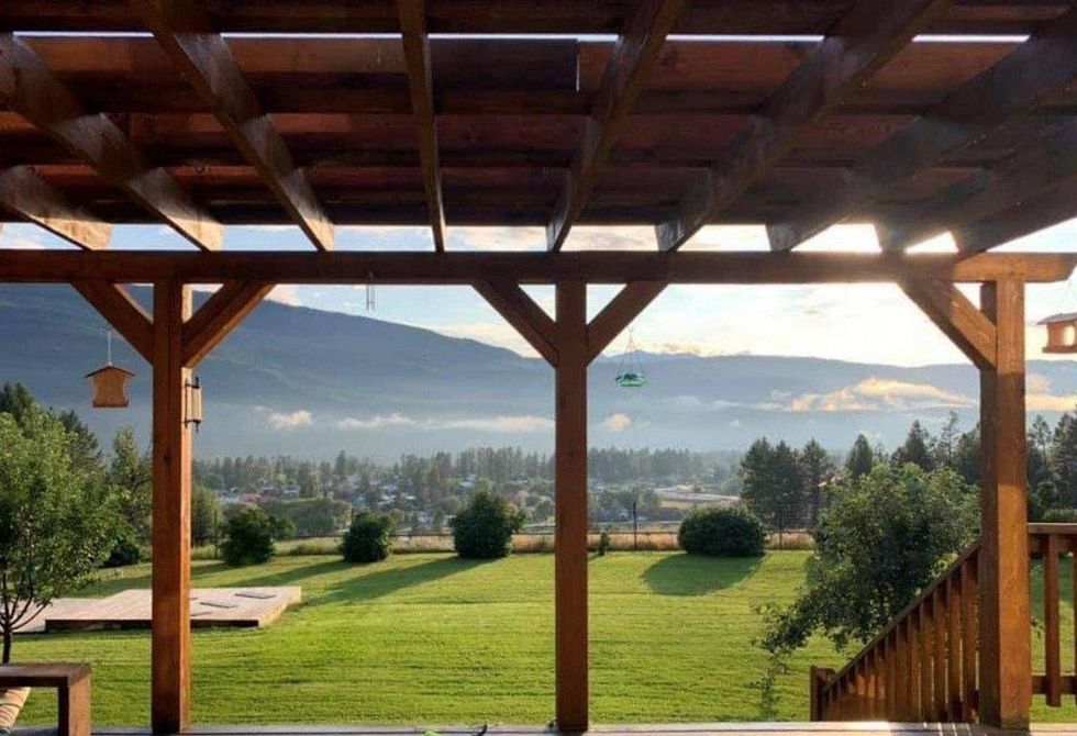 The view from the patio on the green field and the mountains at the country house for sale.