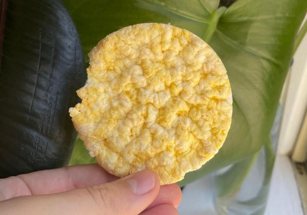The yellowish corn cake being held.