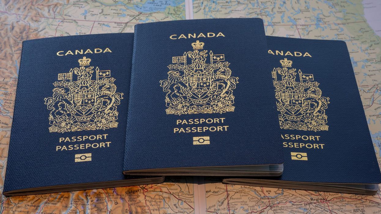 Three Canadian passports against map of Canada.