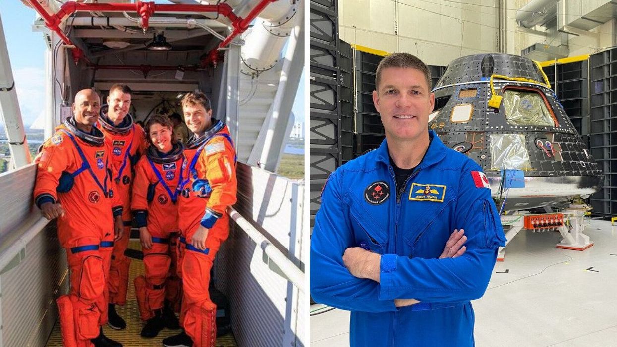 Three men and a woman in orange astronaut suits on a metal bridge to a rocket.