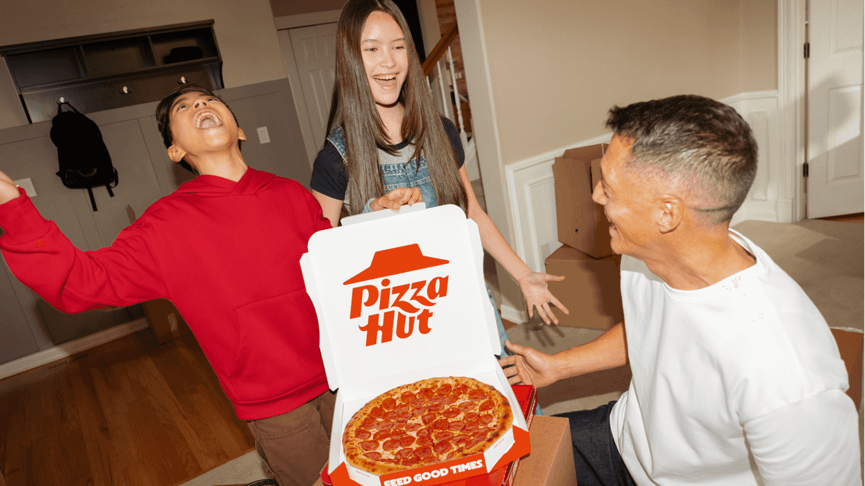 Three people around an open Pizza Hut box.